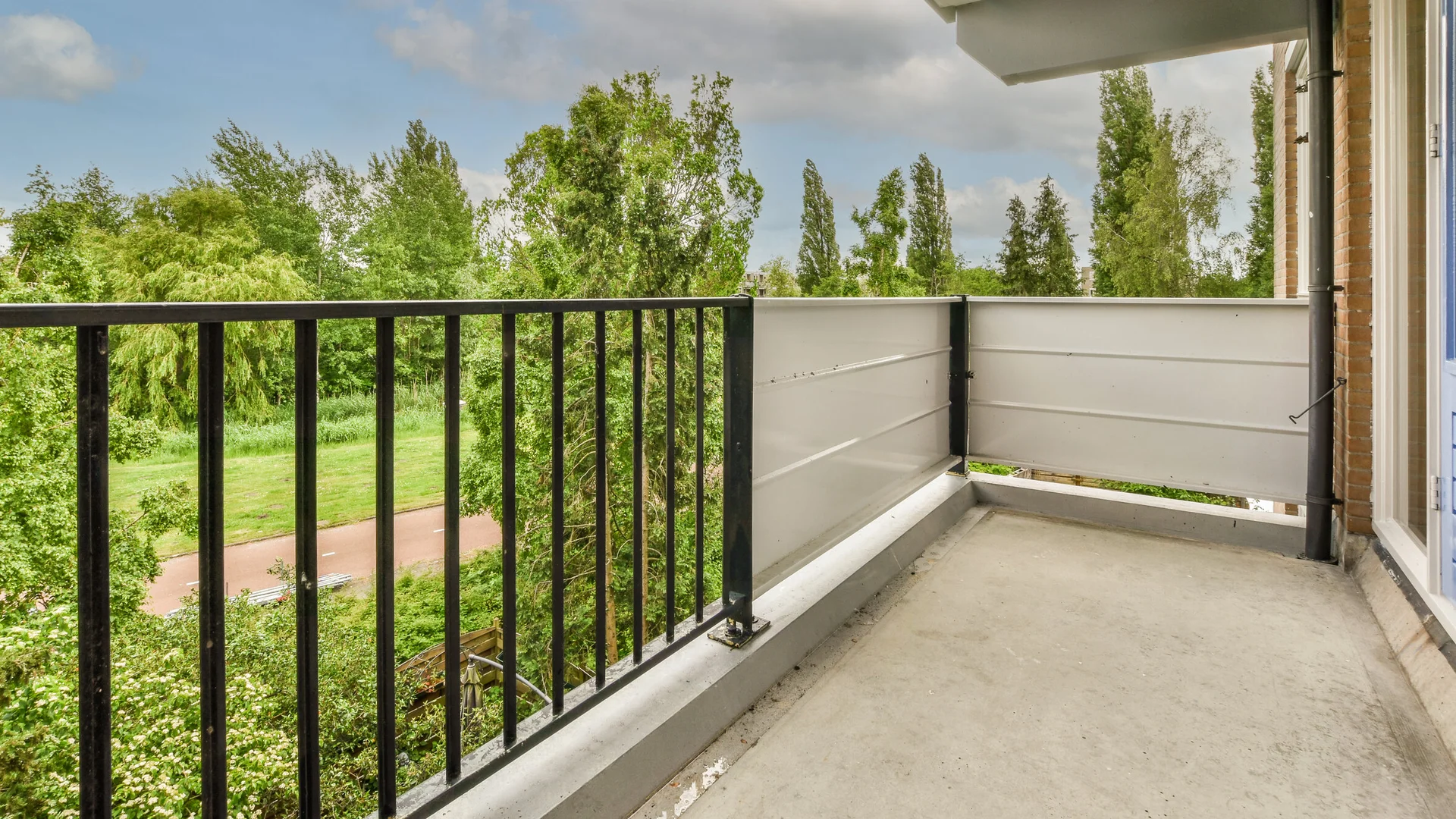 Balkon mit Metallgeländer und Blick ins Grüne