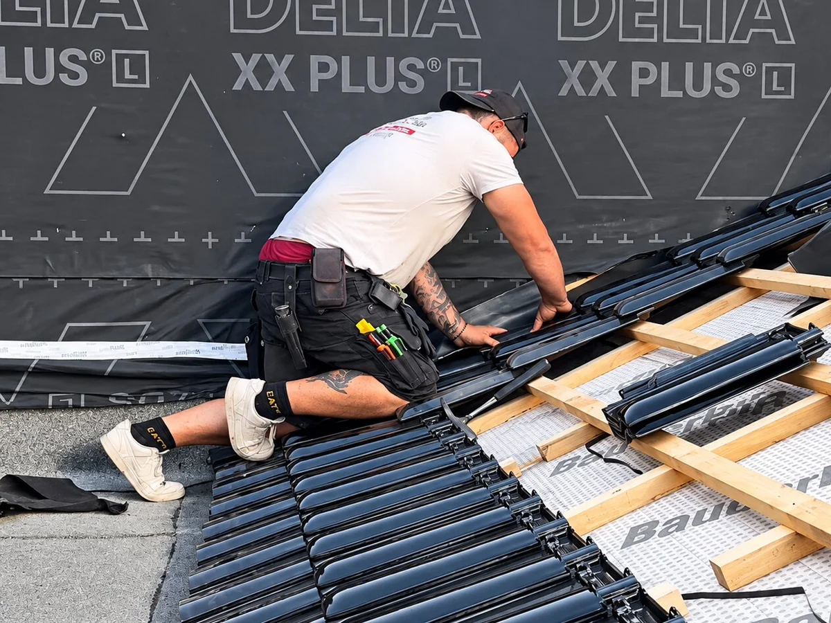 Dachdecker verlegt Solarschienen auf Dach