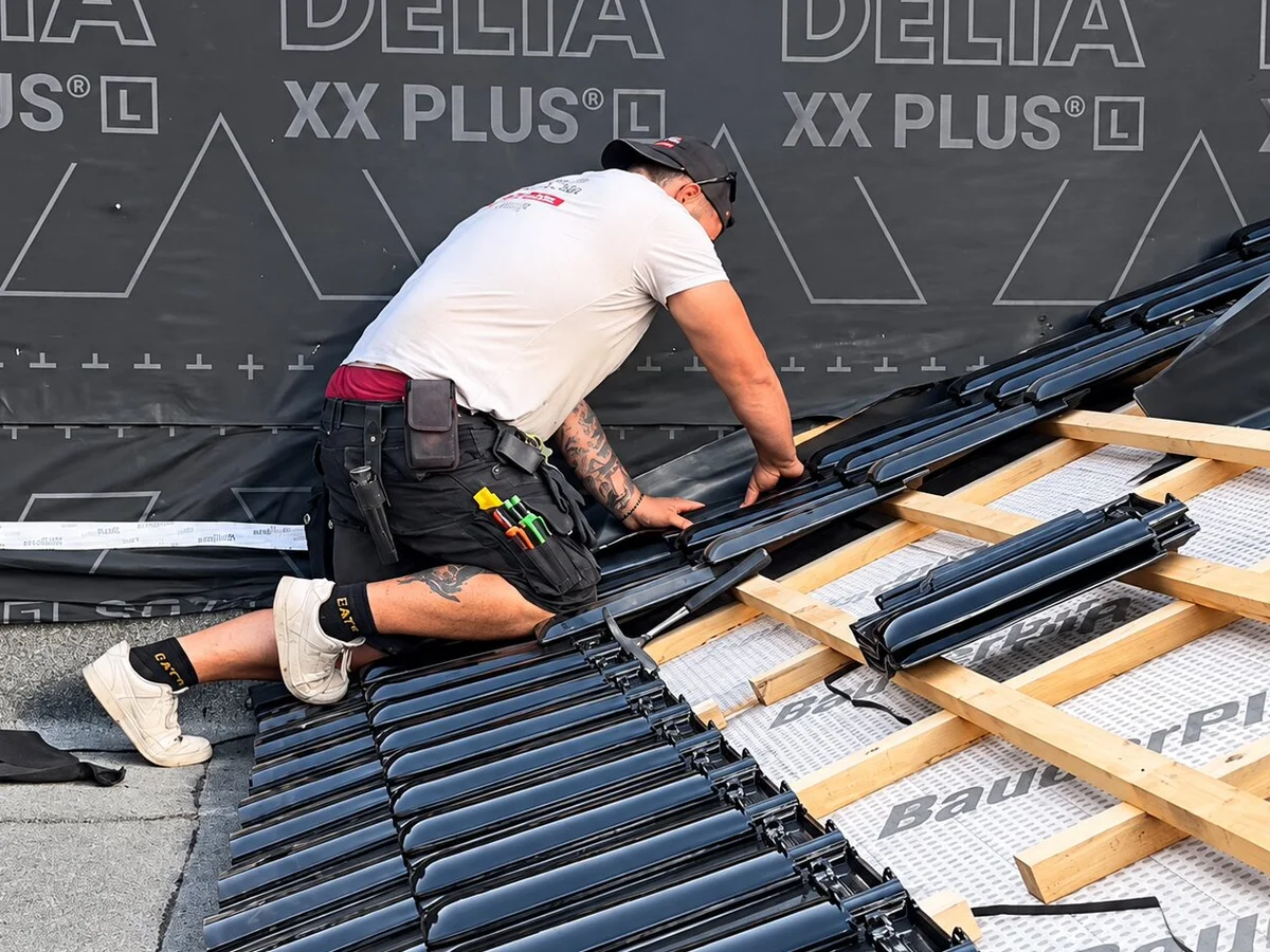 Dachdecker verlegt Solarschienen auf Dach