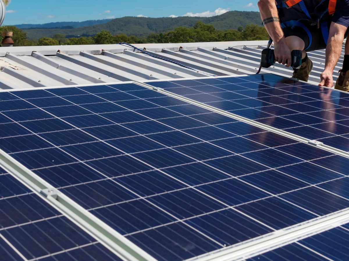 Handwerker montiert Photovoltaikanlage auf Dach