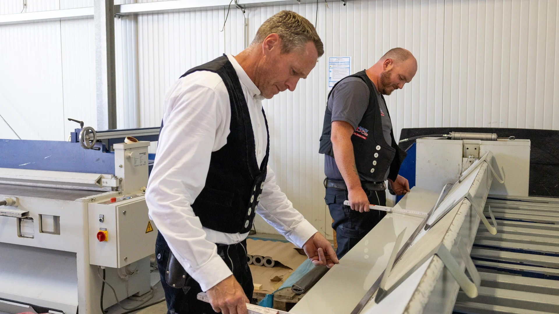 Mitarbeiter vermessen Blech an der Abkantbank
