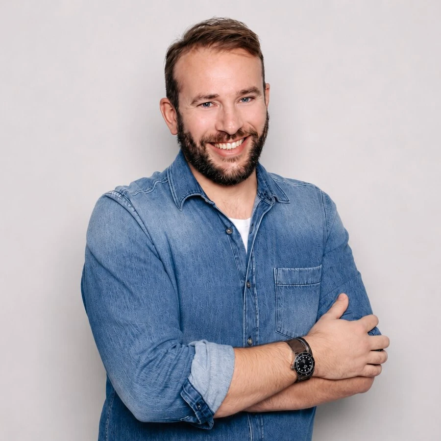 Sebastian Kessel lächelt mit verschränkten Armen